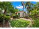 Charming backyard featuring lush tropical landscaping, a manicured lawn, and a quaint storage shed at 1530 21St N Ave, St Petersburg, FL 33704