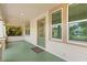 Charming front porch with a decorative glass door, three windows, and painted green floors at 1530 21St N Ave, St Petersburg, FL 33704