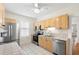 Functional kitchen featuring stainless steel appliances, light wood cabinets, and tiled countertops at 1530 21St N Ave, St Petersburg, FL 33704