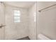 This bathroom features tile walls, a shower and a window allowing natural light to illuminate the room at 15801 Cottontail Pl, Tampa, FL 33624