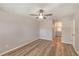 Neutral bedroom with wood-look flooring, a ceiling fan, and an ensuite bathroom at 15801 Cottontail Pl, Tampa, FL 33624