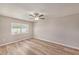 Neutral bedroom with wood-look flooring, a ceiling fan, and a window with natural light at 15801 Cottontail Pl, Tampa, FL 33624