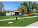Well-maintained home featuring lush landscaping, a paved walkway, mature trees, and a long driveway at 15801 Cottontail Pl, Tampa, FL 33624