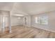 Open-concept living area with wood-look floors and large windows, with views into the kitchen and dining area at 15801 Cottontail Pl, Tampa, FL 33624
