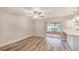 Cozy living space with wood-look floors, a ceiling fan, and a sliding glass door to the patio at 15801 Cottontail Pl, Tampa, FL 33624