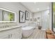 Elegant bathroom with a soaking tub, dual vanities, granite countertops, and a glass-enclosed shower at 17 Franklin S Ct # C, St Petersburg, FL 33711
