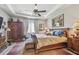 Comfortable bedroom featuring a tray ceiling, ceiling fan, and stylish wooden furniture at 17 Franklin S Ct # C, St Petersburg, FL 33711