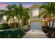 Inviting townhouse showcasing a manicured front yard, palm trees, a two-car garage, and a charming facade at 17 Franklin S Ct # C, St Petersburg, FL 33711