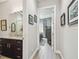 Hallway view towards a well-lit bedroom with dark wood furniture, complemented by a bathroom with a dark wood vanity at 17 Franklin S Ct # C, St Petersburg, FL 33711