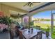 Inviting lanai with comfortable seating and dining area surrounded by lush plants overlooking the serene lake at 17 Franklin S Ct # C, St Petersburg, FL 33711