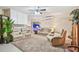 Comfortable living room featuring plush reclining sofas, ceiling fan, and neutral carpeting, perfect for relaxing and entertaining guests at 17 Franklin S Ct # C, St Petersburg, FL 33711