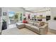 Open-concept living room featuring a comfortable sectional, bright kitchen, and seamless access to the outdoor patio at 17 Franklin S Ct # C, St Petersburg, FL 33711