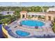 Aerial view of a community pool featuring a spacious deck with lounge chairs and umbrellas, perfect for relaxation at 17 Franklin S Ct # C, St Petersburg, FL 33711