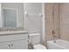 Bright bathroom featuring a tiled shower, white vanity with stone countertop, and modern fixtures at 18827 Henequen Lane, Spring Hill, FL 34610