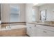 Elegant bathroom features a soaking tub, double vanities with granite countertops, and ample natural light at 18827 Henequen Lane, Spring Hill, FL 34610