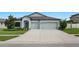 Charming single-Gathering home with a three car garage, a well-manicured lawn, and a concrete driveway at 18827 Henequen Lane, Spring Hill, FL 34610