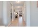 Hallway with neutral tile floors leading to a living space and bedroom, showing a well-lit and inviting interior at 18827 Henequen Lane, Spring Hill, FL 34610