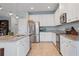 Modern kitchen with stainless steel appliances, granite countertops, white cabinets and tiled flooring at 18827 Henequen Lane, Spring Hill, FL 34610