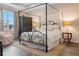 Serene bedroom with a canopy bed, wood floors, neutral walls, and natural light from the large window at 18827 Henequen Lane, Spring Hill, FL 34610