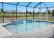 Screened-in pool with water feature and a view of a lake surrounded by neighboring houses at 18827 Henequen Lane, Spring Hill, FL 34610