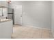 Bright kitchen area with tiled floor, stainless steel fridge, neutral paint, and a back door entrance at 2038 16Th S St, St Petersburg, FL 33705