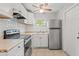 Bright and clean kitchen with white cabinets, stainless steel refrigerator and stove, and tiled flooring at 2038 16Th S St, St Petersburg, FL 33705
