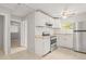 Well-lit kitchen features stainless steel refrigerator, white cabinets and a tile floor at 2038 16Th S St, St Petersburg, FL 33705
