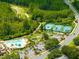 An aerial view showcasing tennis courts, a community pool, a putting green, and ample parking nestled within a residential area at 21209 Diamonte Dr, Land O Lakes, FL 34637