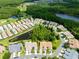 An aerial view of a community with manicured lawns, a tranquil pond, and mature trees surrounding the homes at 21209 Diamonte Dr, Land O Lakes, FL 34637