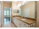 Bright bathroom with a double sink vanity, a large mirror, and tile flooring with a view of the living room at 21209 Diamonte Dr, Land O Lakes, FL 34637