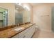 Bright bathroom with a double sink vanity, a large mirror, a walk-in shower, and tile flooring at 21209 Diamonte Dr, Land O Lakes, FL 34637
