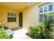Charming entryway with green door, bench, shutters, and manicured greenery, creating a welcoming first impression at 21209 Diamonte Dr, Land O Lakes, FL 34637