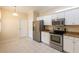 Well-lit kitchen offers modern stainless steel appliances, white cabinets, and tiled flooring at 21209 Diamonte Dr, Land O Lakes, FL 34637