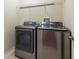 This laundry room features new washer and dryer units, overhead shelving and neutral paint at 21209 Diamonte Dr, Land O Lakes, FL 34637