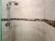 Modern tiled shower with mosaic accents, glass shelves, and a rainfall showerhead, creating a luxurious bathing experience at 21209 Diamonte Dr, Land O Lakes, FL 34637