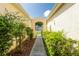 Landscaped walkway leading through an arched gate with lush greenery, creating a serene and inviting entrance at 21209 Diamonte Dr, Land O Lakes, FL 34637