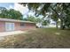 Spacious backyard with grass, mature trees, and a concrete patio at 2121 23Rd Sw St, Largo, FL 33774
