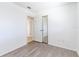 Empty bedroom boasts wood-look flooring and a mirrored closet with interior hallway view at 2121 23Rd Sw St, Largo, FL 33774