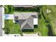 Birds-eye view of the home's roof, driveway, and lush surrounding lawn and landscaping at 2227 North Creek Ct, Sun City Center, FL 33573