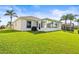 A well-kept yard features plenty of lawn space and a glass sunroom connected to the house at 2227 North Creek Ct, Sun City Center, FL 33573