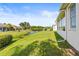 A large backyard adjoins the water and has a view of the trees and a neighboring house at 2227 North Creek Ct, Sun City Center, FL 33573