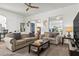 Comfortable living room with two sofas, neutral carpeting, ceiling fan, and ample natural light at 2227 North Creek Ct, Sun City Center, FL 33573