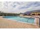 Inviting outdoor pool with brick patio, lounge chairs, and umbrellas surrounded by lush landscaping and community buildings at 2227 North Creek Ct, Sun City Center, FL 33573