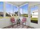 Enclosed patio with chairs and a table overlooking a pond with mature trees at 2227 North Creek Ct, Sun City Center, FL 33573