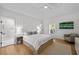 Bright main bedroom featuring a ceiling fan, ensuite bathroom, and minimalist modern design at 2603 Sanders Dr, Tampa, FL 33611
