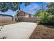 Large backyard with a spacious concrete area, wooden fences and a home under construction in the background at 2720 14Th N Ave, St Petersburg, FL 33713