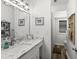 Bright bathroom with a marble countertop, framed nautical art, and a walk-in shower with tiled flooring at 2720 14Th N Ave, St Petersburg, FL 33713