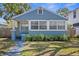 Blue bungalow with white trim, showcasing a quaint front yard and garden at 2720 14Th N Ave, St Petersburg, FL 33713