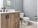 Cozy bathroom featuring a wood vanity, toilet, neutral paint, and tile flooring at 3003 W Leila Ave, Tampa, FL 33611