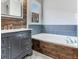 Bathroom highlighting a soaking tub, a vanity, and a bright window at 3003 W Leila Ave, Tampa, FL 33611